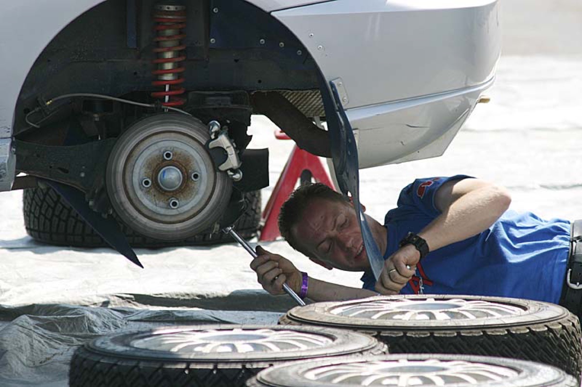 タイヤを外した車体下部を点検する整備士
